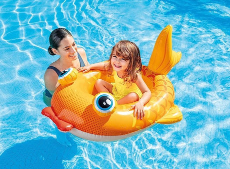 Smiling child riding the Intex Fish Pool Cruiser float in a swimming pool with an adult in Ireland