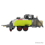Side profile of the BRIXIES Plus CLAAS QUADRANT 5300 FC showing the side ladder, lime green baler body, twin red rimmed wheels and drawbar