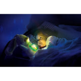 Young child lying in bed beside the Arctic Bunny Projector, with green and yellow light glowing from the bunny's tummy and blue lighting across the bedroom.