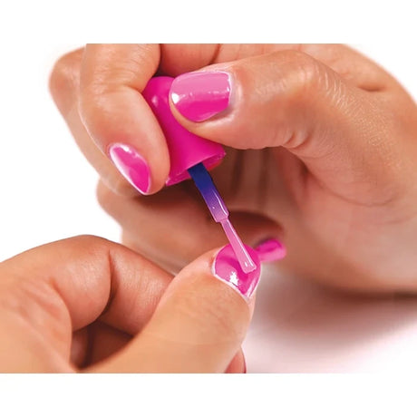 Close-up of pink nail polish being applied to a fingernail using a small brush, with glossy pink painted nails visible.