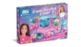 Clementoni Idea Crystal Jewellery Creator retail box showing a purple crystal workstation, blue crystal growing cup, gemstone jewellery, two children and 8+ age marking.