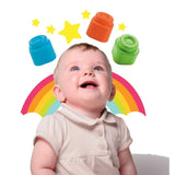 Smiling baby wearing a cream polo shirt looking upwards at illustrated blue, orange and green Soft Clemmy blocks, with yellow stars and a colourful rainbow behind.