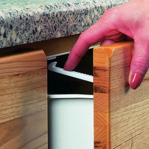 Clippasafe latch fitted inside a drawer opening, with one part fixed to the cabinet interior and the matching catch fixed to the drawer front.