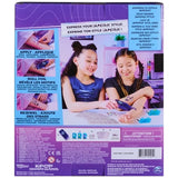 Back of Cool Maker KPop Demon Hunters Shimmer Me Tattoo packaging showing two girls applying tattoos, illustrated application instructions and the included tattoo kit contents.