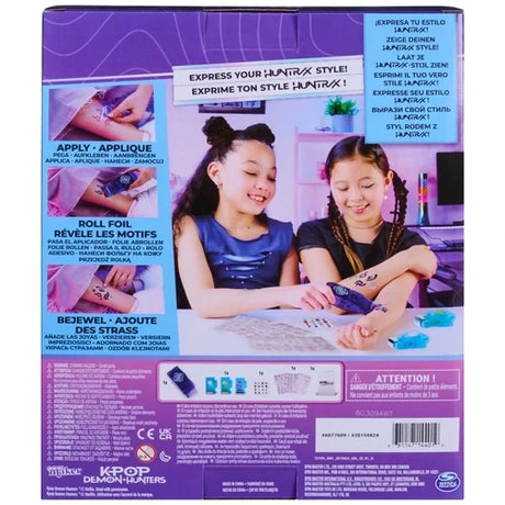 Back of Cool Maker KPop Demon Hunters Shimmer Me Tattoo packaging showing two girls applying tattoos, illustrated application instructions and the included tattoo kit contents.