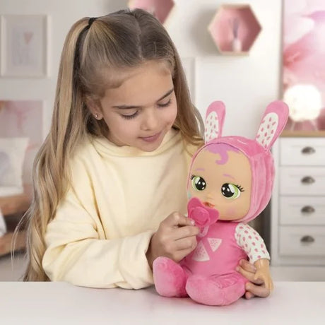 Child interacting with Cry Babies Meal Time Julie doll using her matching dummy accessory.