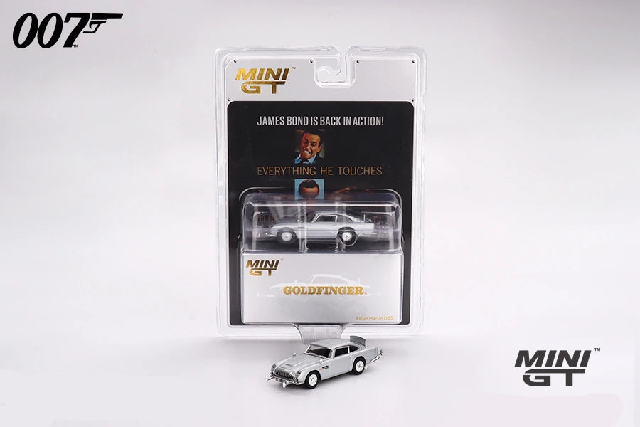Mini GT Goldfinger Aston Martin DB5 displayed with its 007 blister packaging and a loose silver DB5 model positioned in front
