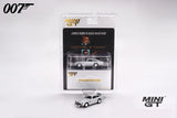 Mini GT Goldfinger Aston Martin DB5 displayed with its 007 blister packaging and a loose silver DB5 model positioned in front