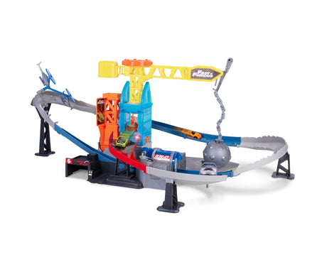 Dickie Toys Fast & Furious Wrecking Crash Course assembled track with yellow crane, swinging grey wrecking ball, orange building section, blue ramps and toy cars on a white background.