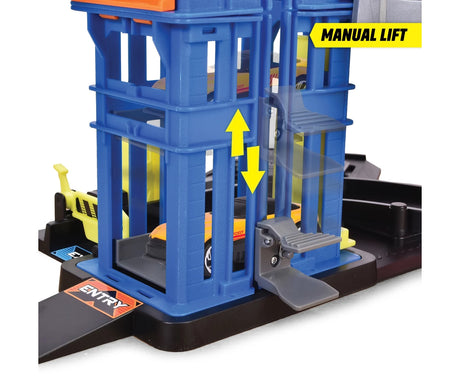 Close-up of the Dickie Parking Station Garage manual lift with an orange and yellow car inside the blue lift tower, grey operating lever and directional arrows.