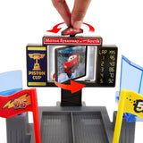 Close up of Disney Pixar Cars playset with fingers pressing red button above rotating screen