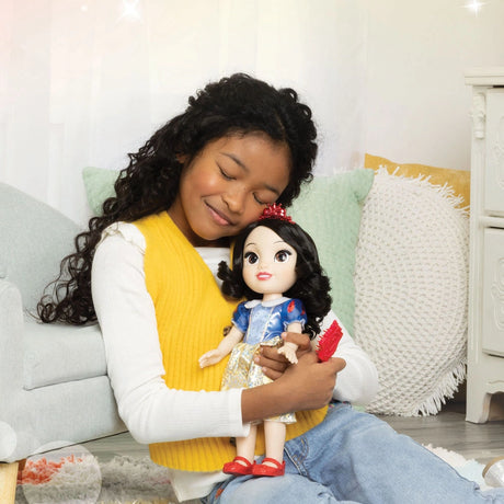 Child holding the Disney Princess Snow White doll while brushing her hair