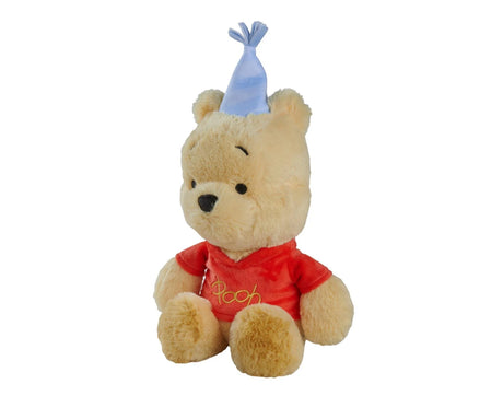 Disney Winnie the Pooh Anniversary 25cm plush soft toy shown at a slight angle, seated with red embroidered top and light blue party hat
