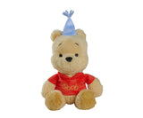 Disney Winnie the Pooh Anniversary 25cm plush seated front-facing view wearing a red Pooh-embroidered top and a light blue party hat