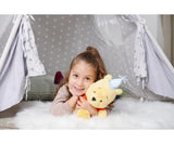 Child lying on a white fluffy rug inside a grey star-print play tent, cuddling the Disney Winnie the Pooh Anniversary 25cm plush with blue party hat