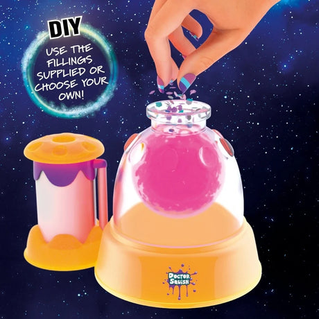 Doctor Squish Squishy Maker Glow It station with a hand adding decorative pieces to a pink squishy inside the maker