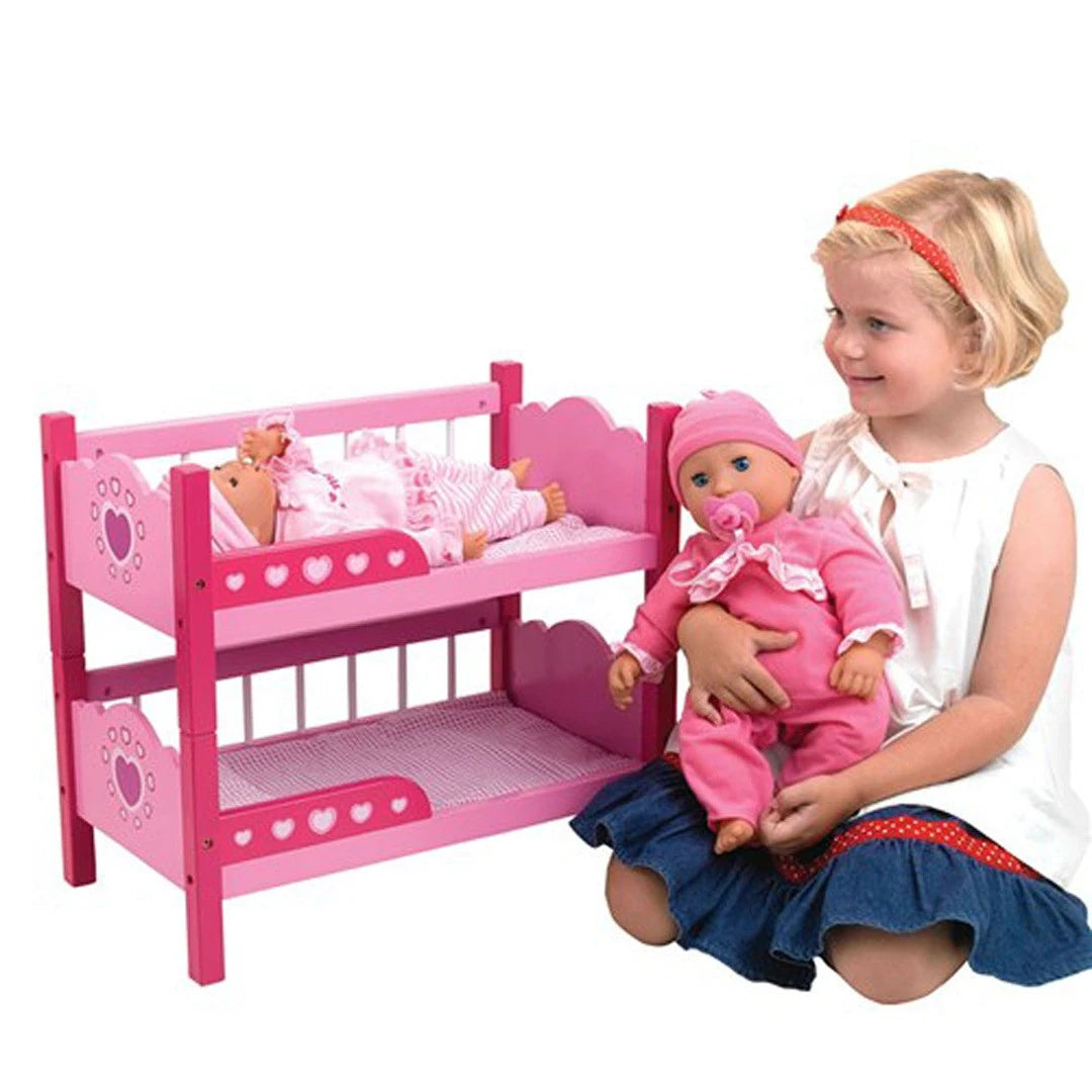 Child holding a doll beside the pink Dolls World bunk beds with two smaller dolls lying on the top bunk