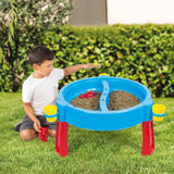 Child beside a blue Dolu sand and water activity table filled with sand on grass