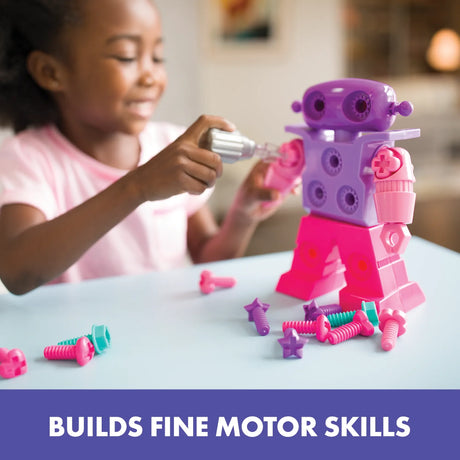 Child using toy screwdriver to attach bolts to SparkleBot robot on a table – Ireland