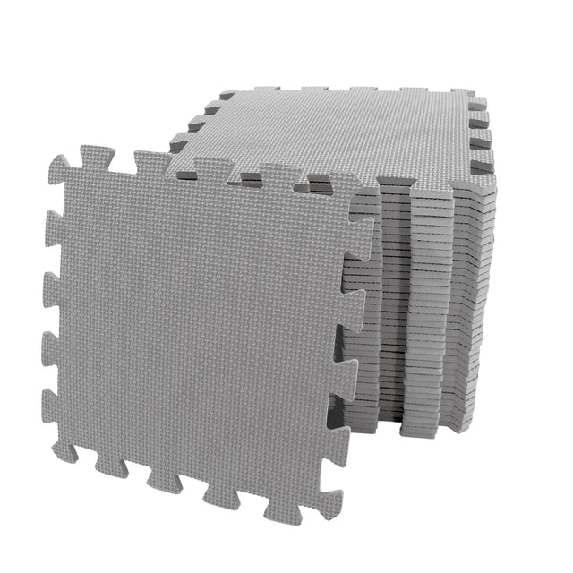 Stack of grey interlocking EVA foam play mats with one tile leaning forward showing textured surface and puzzle edge design