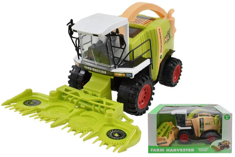Silage forager farm toy with white cab, black tyres, red wheels and bright green header, displayed next to boxed harvester toy