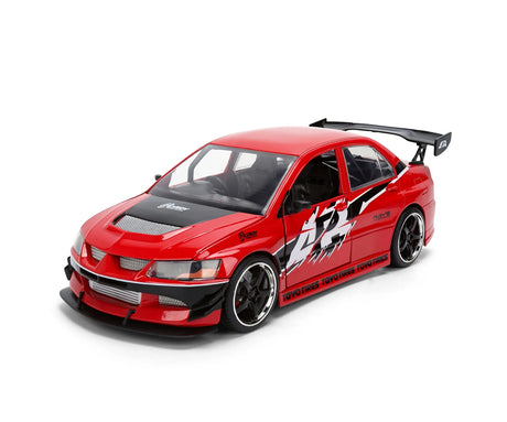 Fast & Furious 2006 Mitsubishi Lancer EVO IX red diecast car viewed from the front and side, showing black bonnet, racing graphics, black wheels and rear spoiler.
