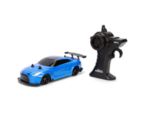 Fast & Furious RC Drift Nissan GT-R R35 blue car viewed from the front and side beside its black pistol grip remote controller.