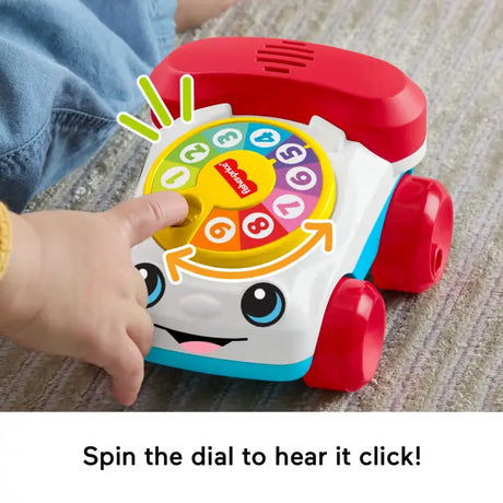 Hands spinning the rotary dial on the Fisher-Price Chatter Telephone Vehicle
