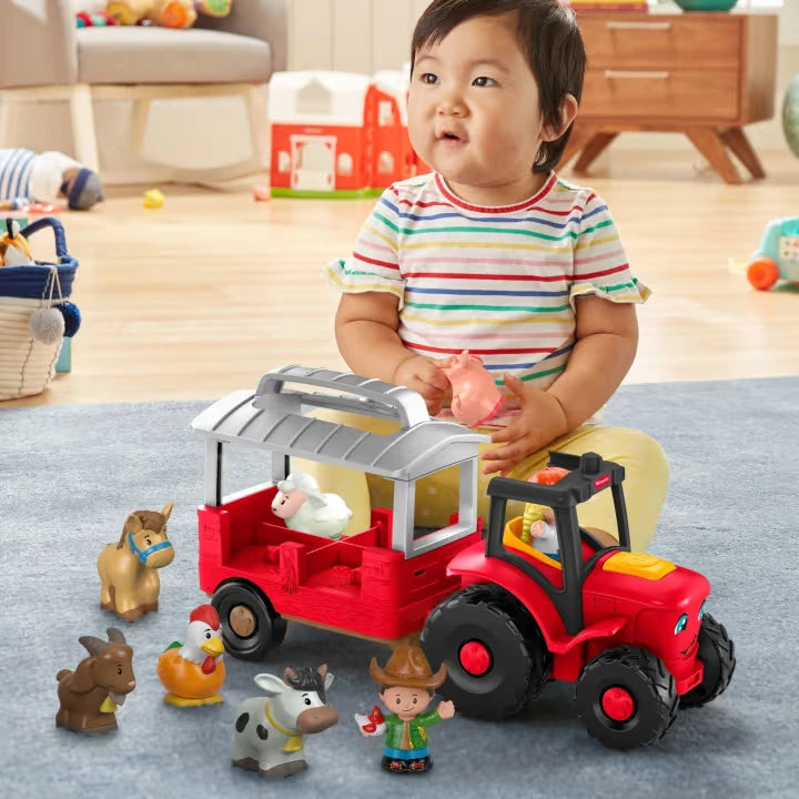 Fisher-Price Little People Caring for Animals Tractor with child holding pig figure beside tractor and farm animals