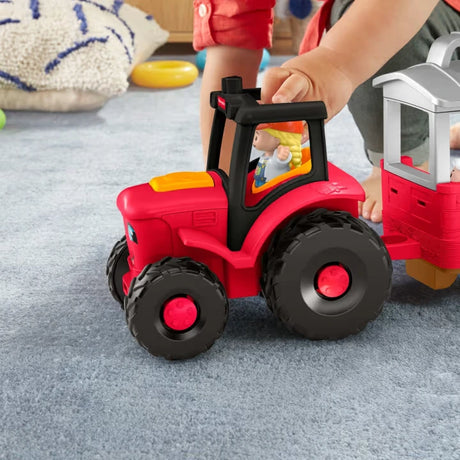 Fisher-Price Little People Caring for Animals Tractor close view with farmer figure in driver seat and child pressing tractor