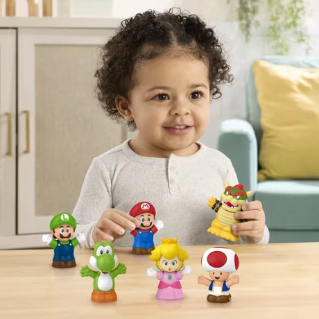 Child at a table with Mario, Luigi, Bowser, Princess Peach, Yoshi and Toad Little People figures