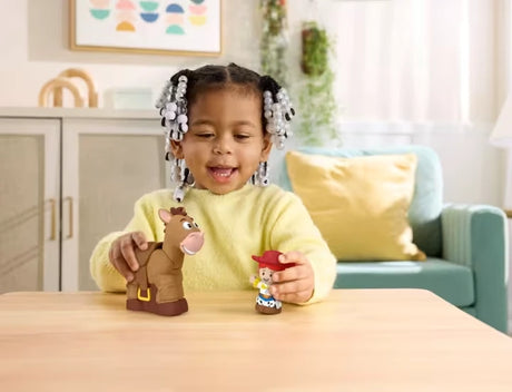 Child playing with Fisher-Price Little People Toy Story Jessie and Bullseye figures