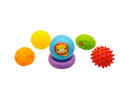 Six Fisher-Price baby sensory toys laid out individually, including textured balls and a purple sensory ring