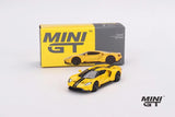 Ford GT Triple Yellow Mini GT model displayed in front of its box with the yellow body, black centre stripes and dark wheels visible