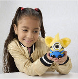 Child holding Furby Furblets Minions plush toy with goggle accessory