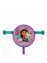 Close-up of the circular handlebar disc featuring Gabby and cat characters on a purple sunburst background with Gabby's Dollhouse branding