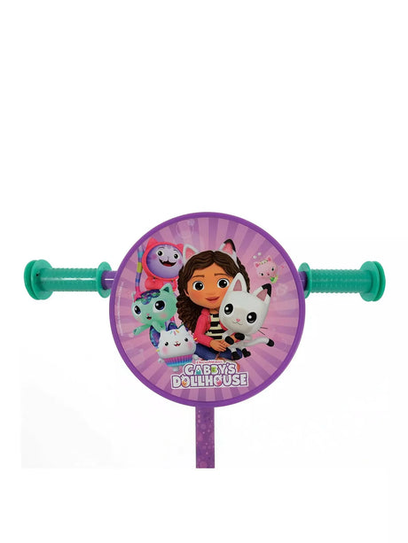 Close-up of the circular handlebar disc featuring Gabby and cat characters on a purple sunburst background with Gabby's Dollhouse branding