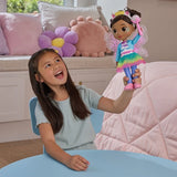 Child holding the Gabby's Dollhouse Dandelion Magic Gabby Doll above a table