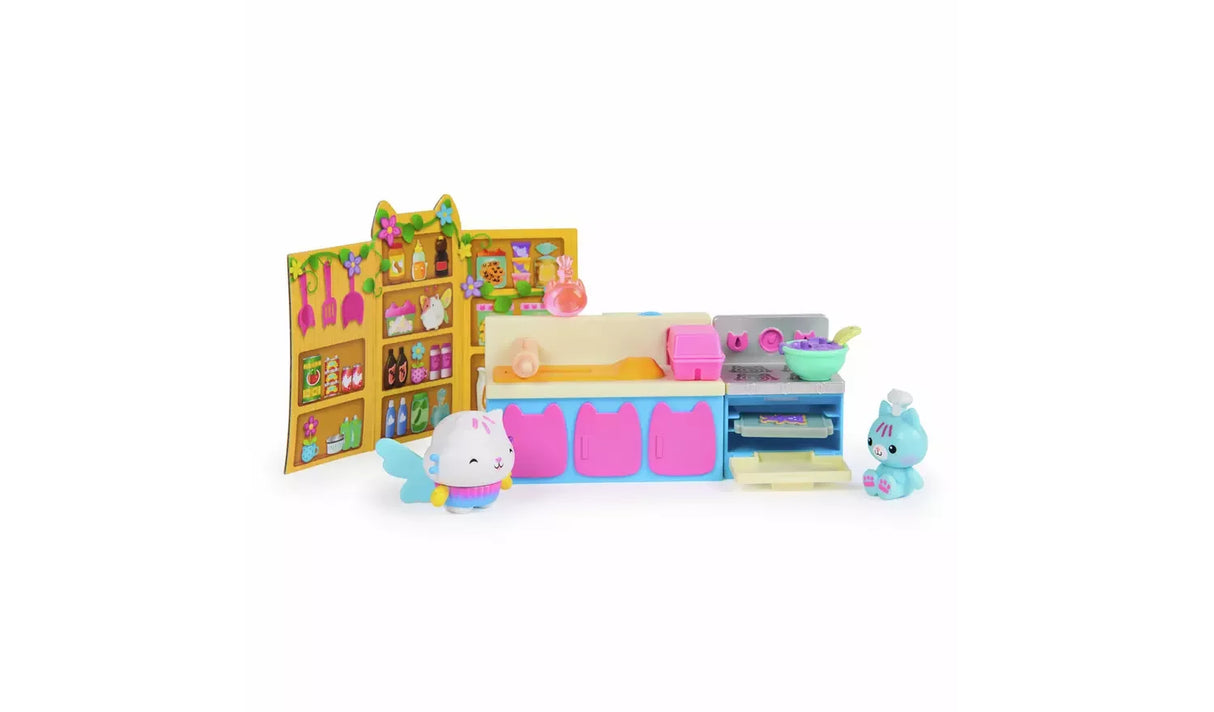 Cakey Cat's Fairy Kitchen with illustrated cupboard backdrop, blue and pink counter, open oven, rolling pin, mixing bowl, winged Cakey Cat figure and blue cat figure wearing a chef hat
