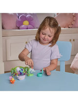 Child playing with the MerCat bathtub, green bathroom stand, pink mirror, orange flower seat and turquoise container on a blue table