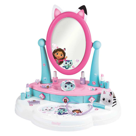 Smoby Gabby's Dollhouse Hairdresser Table Top front view showing pink oval mirror with cat ears, teal stand, pink and teal base with drawers and 12 play accessories laid out