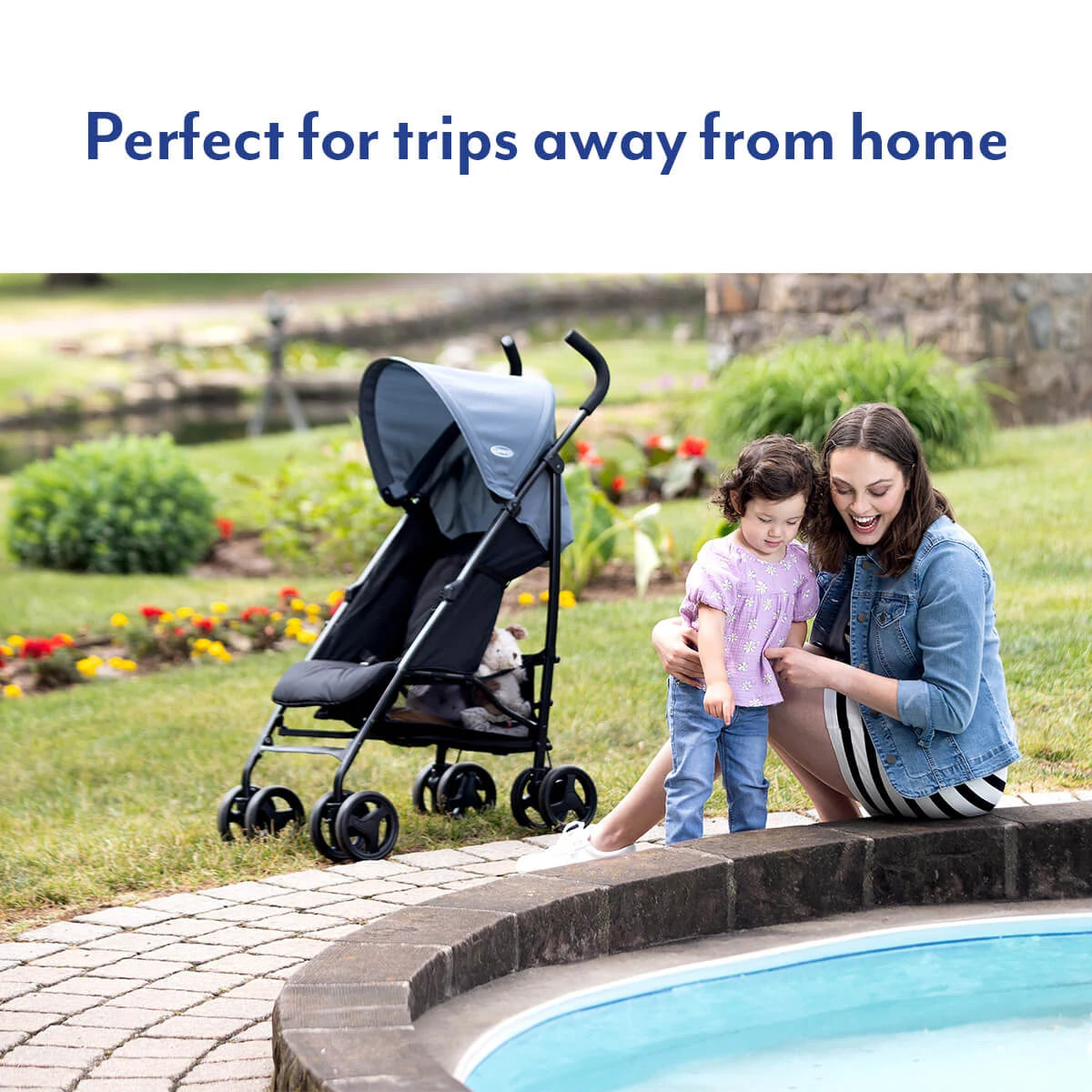 Graco EZLite Midnight stroller beside woman and child on a paved outdoor path