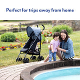 Graco EZLite Midnight stroller beside woman and child on a paved outdoor path