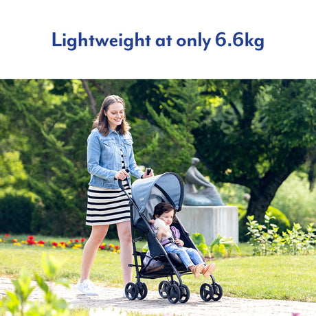 Woman pushing a child in a Graco EZLite Midnight stroller in a garden park