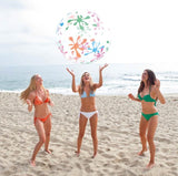 Group playing with Bestway Splash and Play beach ball on sandy beach, Ireland