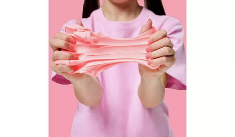 Gui Gui Single Pack pale pink slime pulled apart between two hands showing stretchy butter slime texture