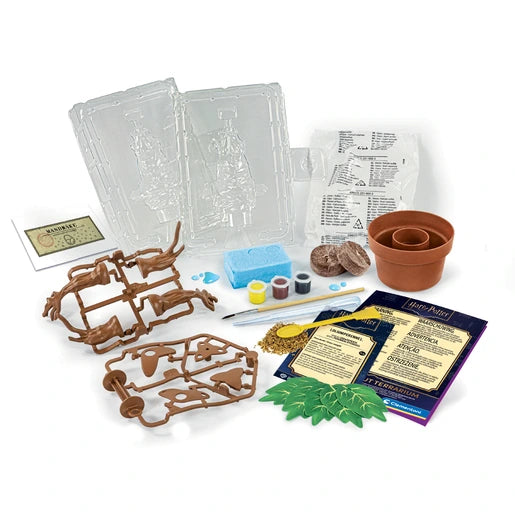 Harry Potter Mandrake Terrarium Kit contents arranged on a white background, including transparent moulds, brown plastic figure parts, plant pot, paint pots, brush, plaster packet, seeds, decorative leaves and instruction booklet.