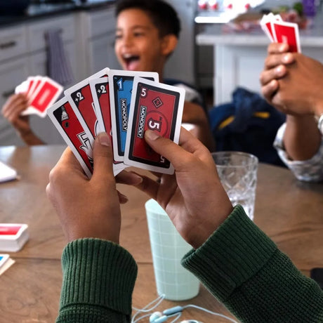 Family playing Monopoly Bid with kids holding colourful cards – Ireland