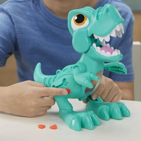 Child pressing Play-Doh into green T-Rex toy with visible jaw and belly movement – Ireland