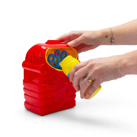Close-up of hands inserting the yellow-capped 118ml bubble solution bottle into the side of the red HGL Bubble Machine, showing the blue wand wheel inside